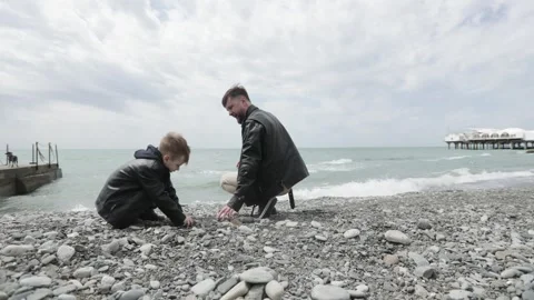 Dad and son give five to each other on the seashore 스톡 동영상 241174362
