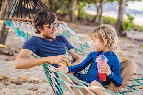 Dad and son having fun in a hammock with a drinks Stock Photos