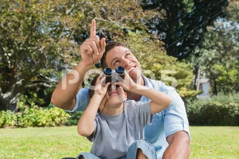 Dad and son looking at the sky with binoculars Stock-Fotos