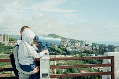 Dad and son looking through stationary binoculars Stock Photos