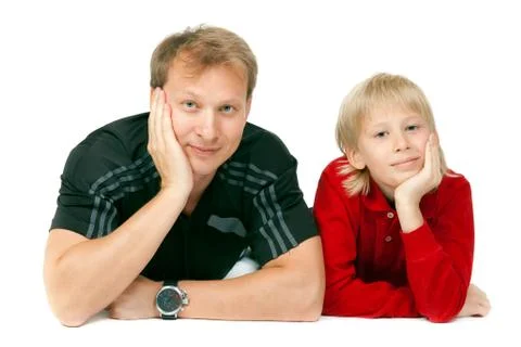Dad and son lying on the floor in the studio Stock Photos