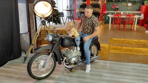 Dad and son play with a motorcycle in a large living room decorated for the new Stock Footage 256010779
