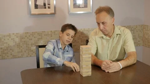 Dad and son playing board game Jenga Stock Footage 70243221