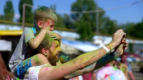 Dad and son pose and smile for a selfie at the Holi festival of colors. Stock Footage 196343092