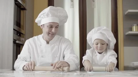 Dad and son rolling out blue sugar paste in their home kitchen. Hands of father 動画素材 155681080