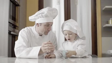 Dad and son rolling out blue sugar paste in their home kitchen. Moments of 動画素材 170114566