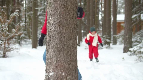 Dad and son run around a tree in winter Stock Footage 129096140