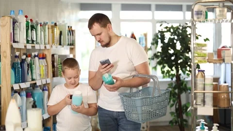 Dad and son scan barcode on packaging of shower gel 動画素材 341377102