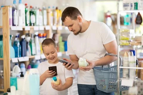 Dad and son scan barcode on packaging of liquid hand soap Stock Photos