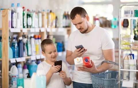 Dad and son scan barcode on packaging of sewer cleaner liquid Foto stock
