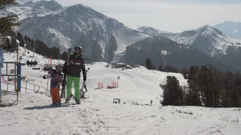 Dad and son Skiing, young ski racers pass, snowy swiss alp mountains and pine Stock Footage 183352902