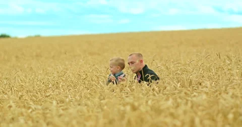 Dad and son spend their holidays together, a walk in the field. Happy dad sits Stock Footage 138960923
