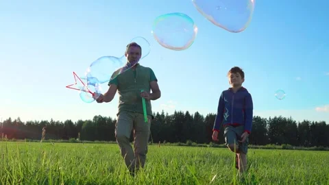 Dad and son spend time together outdoors in the sunset rays of the sun. Stock Footage 234785232