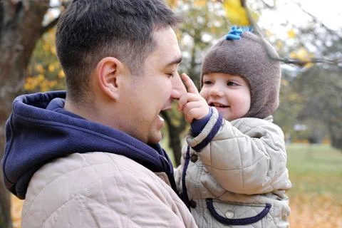 Dad and son spend time together in the autumn park. Father holding his son .. Stock Photos