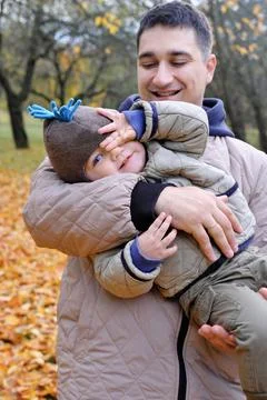 Dad and son spend time together in the autumn park. Father holding his son .. Stock Photos