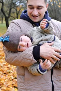 Dad and son spend time together in the autumn park. Father holding his son .. Stock Photos