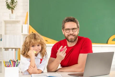 Dad and son study in classroom with laptop, school Fotos Stock