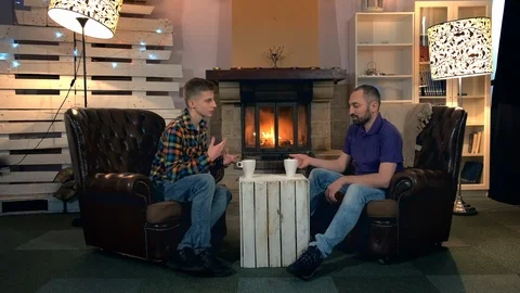 Dad and son talking over a cup of warm drink at home Stock-Footage 113884316