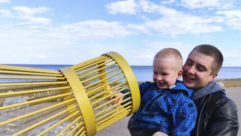 Dad and son throw the plastic bottle into the plastic collection container. Recy Video stock 153525637