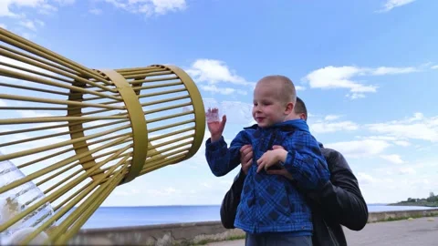 Dad and son throw the plastic bottle into the plastic collection container. Recy Stock Footage 153525688