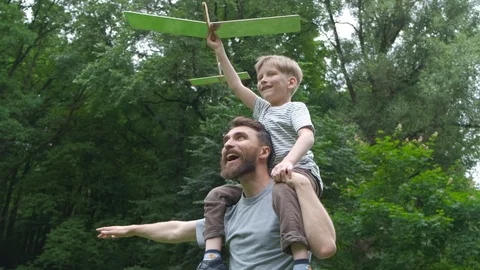 Dad and son together launch model airplane outdoors, both man and boy are Stock Footage 111918248
