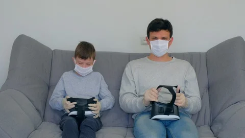 Dad and son using virtual reality glasses in coronavirus pandemic quarantine. Stock Footage 128984750