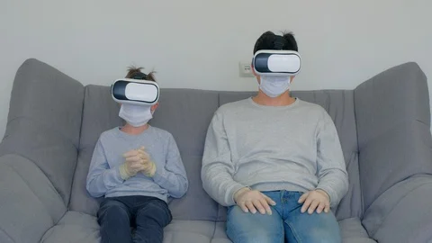 Dad and son using virtual reality glasses in coronavirus pandemic quarantine. Stock Footage 128984935