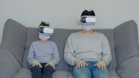 Dad and son using virtual reality glasses in coronavirus pandemic quarantine. Stock Footage 128985144