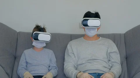 Dad and son using virtual reality glasses in coronavirus pandemic quarantine. Stock Footage 128985303