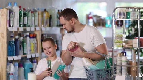 Dad and son visitors purchased necessary goods in store, with full basket of Stock Footage 313875247
