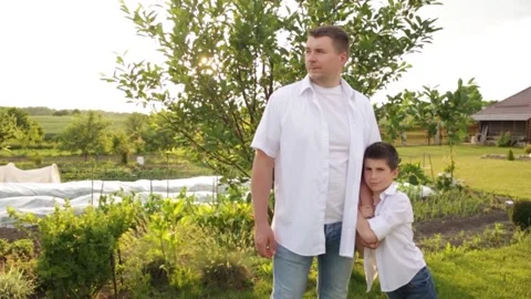 Dad and son walk together in the green garden near the house. Stock-Footage 140366642
