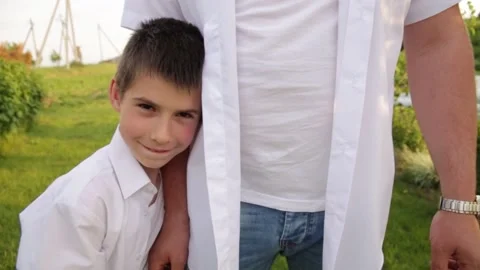 Dad and son walk together in the green garden near the house. Stock Footage 140366885