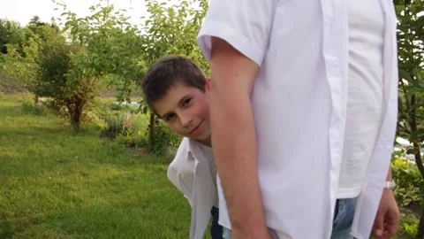 Dad and son walk together in the green garden near the house. Stock-Footage 140367016