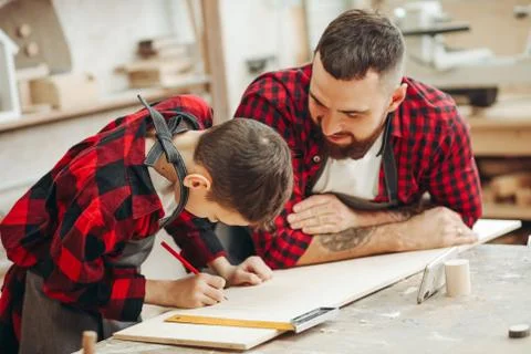 Dad and son in the workshop playing designing a model of a wooden plane Stock Photos