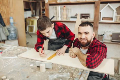 Dad and son in the workshop playing designing a model of a wooden plane Stock Photos