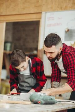 Dad and son in the workshop playing designing a model of a wooden plane Stock Photos