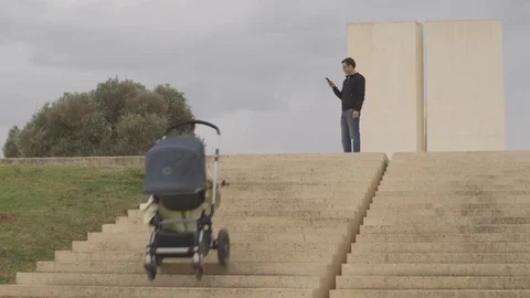 Dad and stroller - Long shot of stroller falling down the stairs Stock Footage 77004331