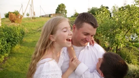 Dad and two children walk together in the green garden near the house. Stock-Footage 140367585