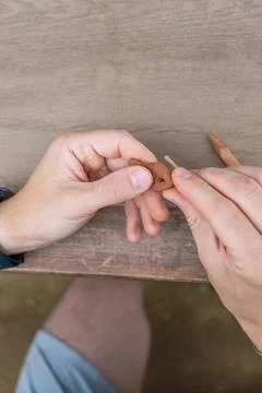 Dad and young son work at the grey table, moulding figures out of red clay Stock Photos