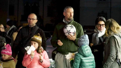 Dad bouncing ball in his hands near his family at night Stock Footage 120969975