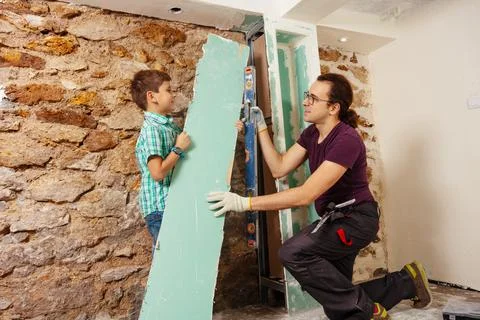 Dad with a boy holding level doing renovation at home Stock Photos
