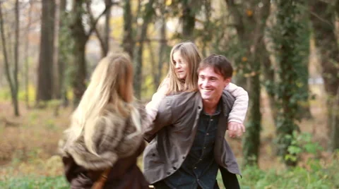 Dad carries daughter on his back while mom spinning around Stock Footage 59554404
