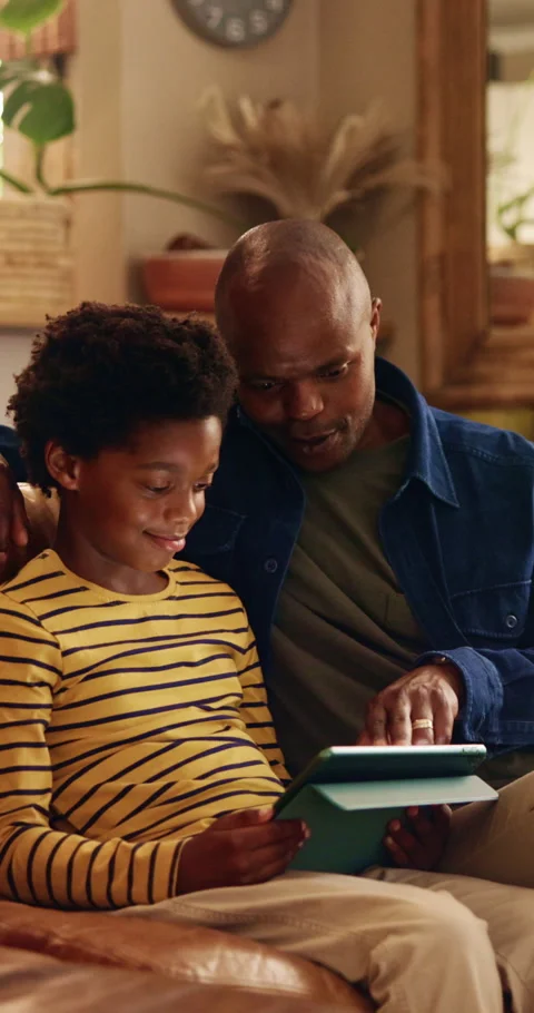 Dad, child and tablet on sofa for elearning, bonding and educational app in home Stock Footage 343239260
