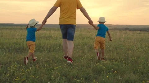 Dad, child are walking through meadow on grass, sunset. Upbringing kids. Dad Stock Footage 249116045