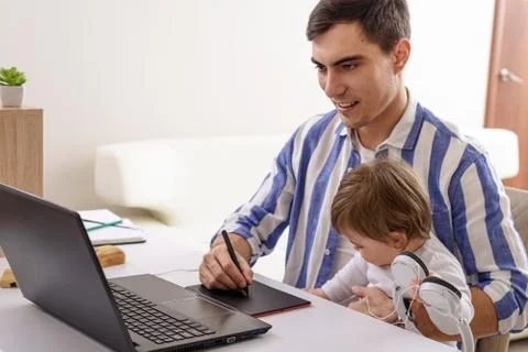 Dad with child on lap, remote work at home on laptop, freelancer, Illustrator Stock Photos