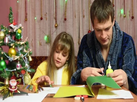 Dad cuts elements from colored paper, my daughter tells what Stock Footage 71613862