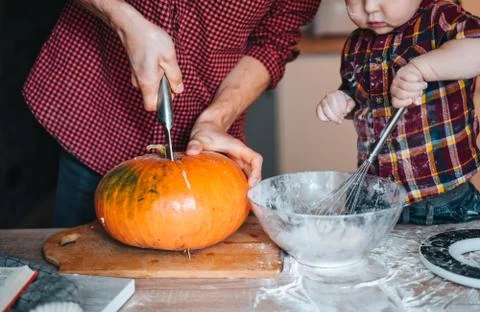 Dad cuts a pumpkin for a pie Stock Photos