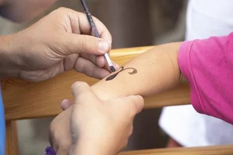 Dad draw with brush black pattern on children's hand, kids party Stock Photos