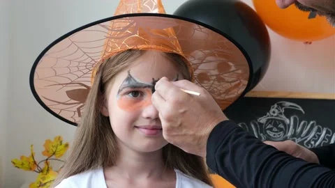 Dad draws aqua makeup on child girl face for Halloween party Video stock 213016293