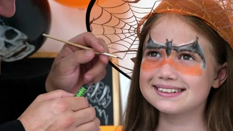 Dad draws aqua makeup on kid girl face for Halloween. Happy family Stock Footage 211399570